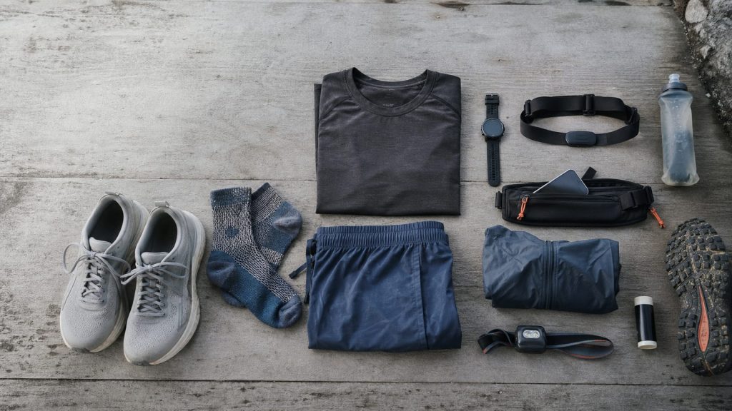 Essential running gear arranged by Ken from shoes and socks to hydration, watch, belt, jacket, and headlamp